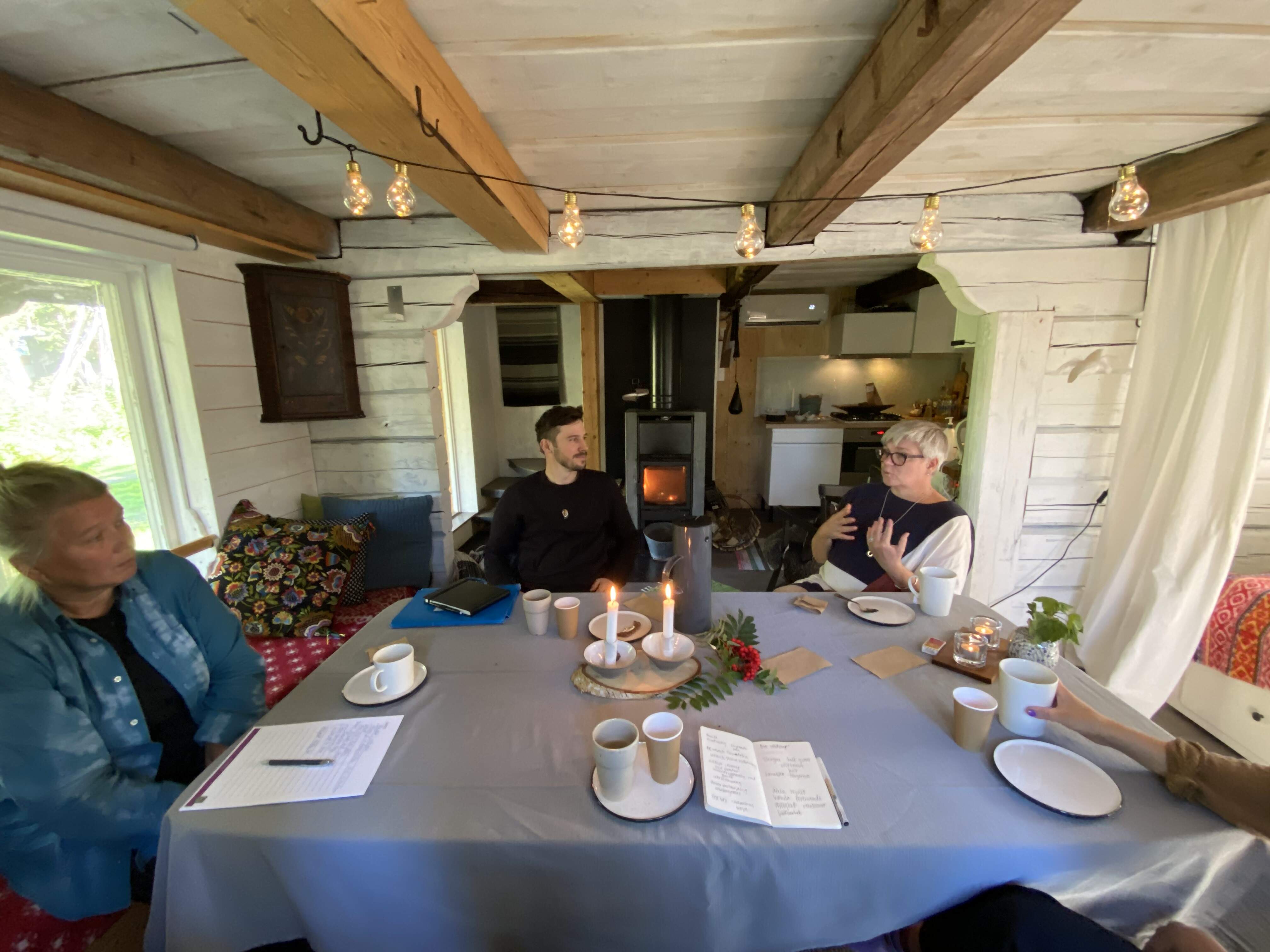 3 personer samtalar runt ett bord på Huuva Hideaway